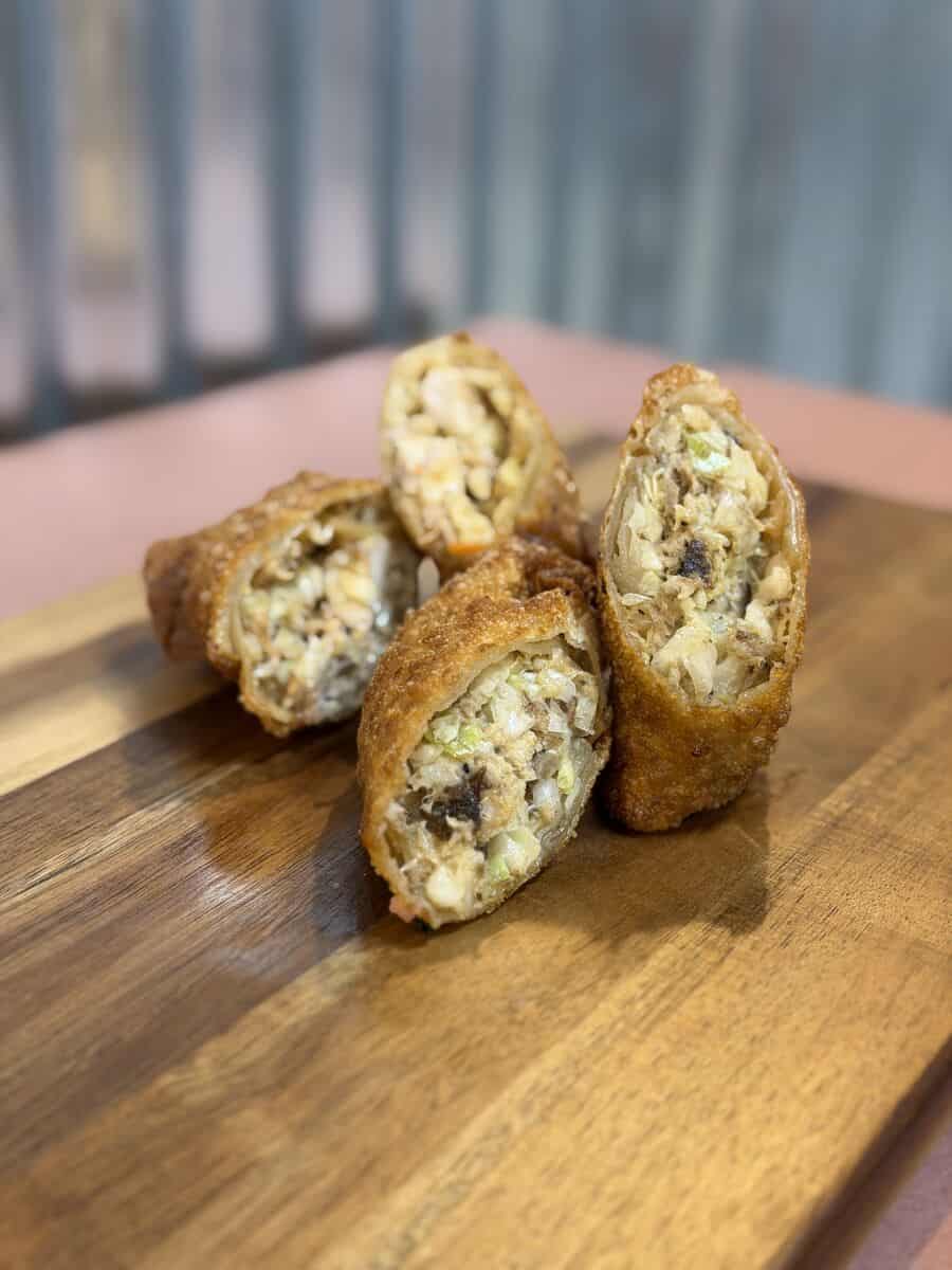 BBQ egg rolls sliced open to show pulled pork and coleslaw filling